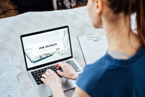 Applicant using a laptop to search for an open sales job.