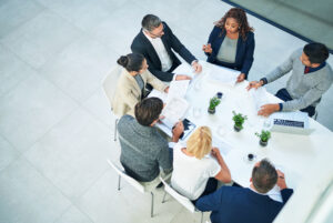 Professionals gather around a table to plan a marketing approach