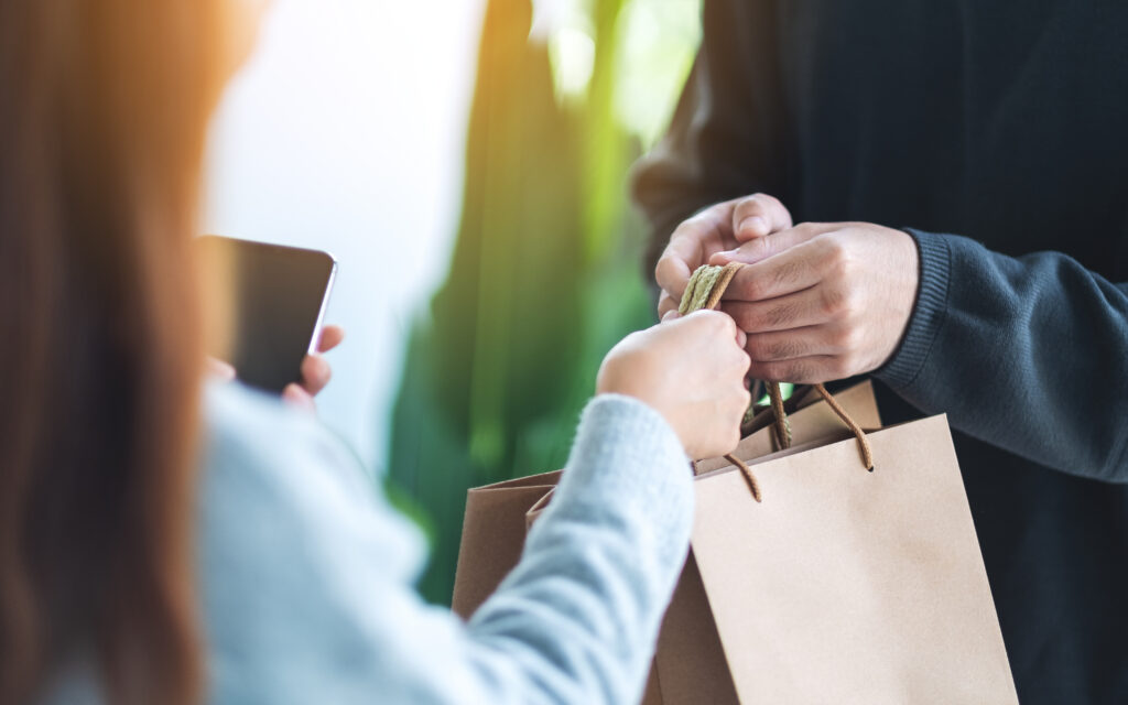 A hand holding a shopping bag, showing a repeat purchase.